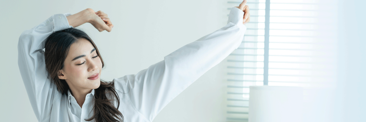 Woman stretching in front of a window with blinds