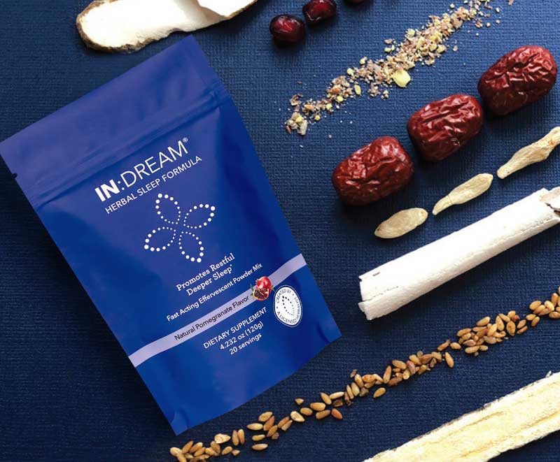 IN DREAM herbal sleep formula package on a blue background with dried herbs and dates.